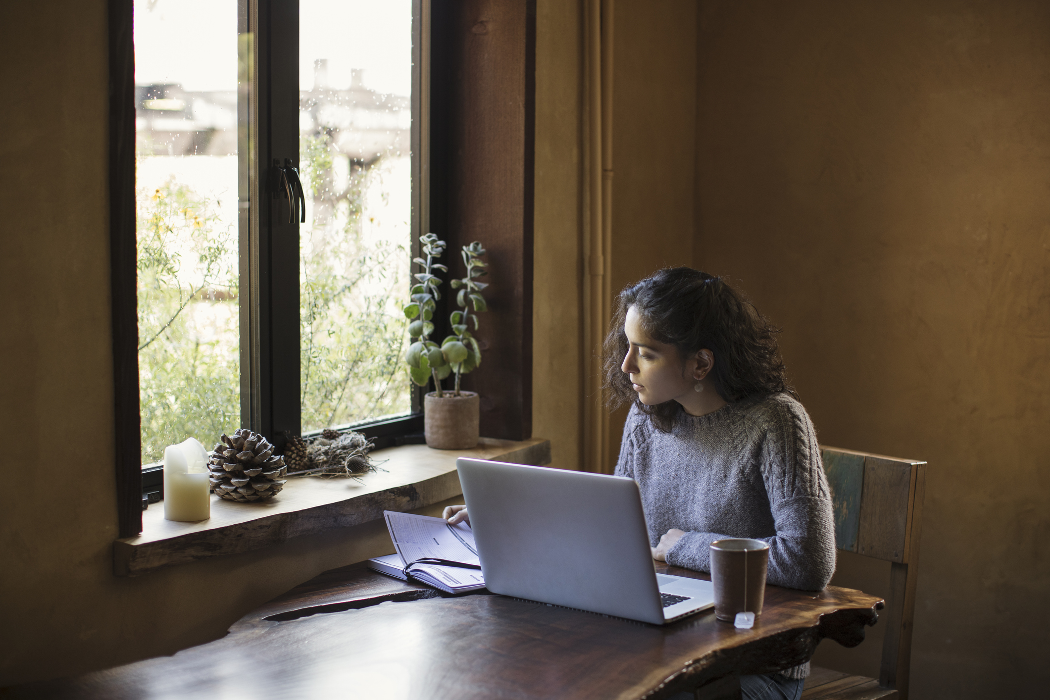 A woman sits at her computer in a cafe.