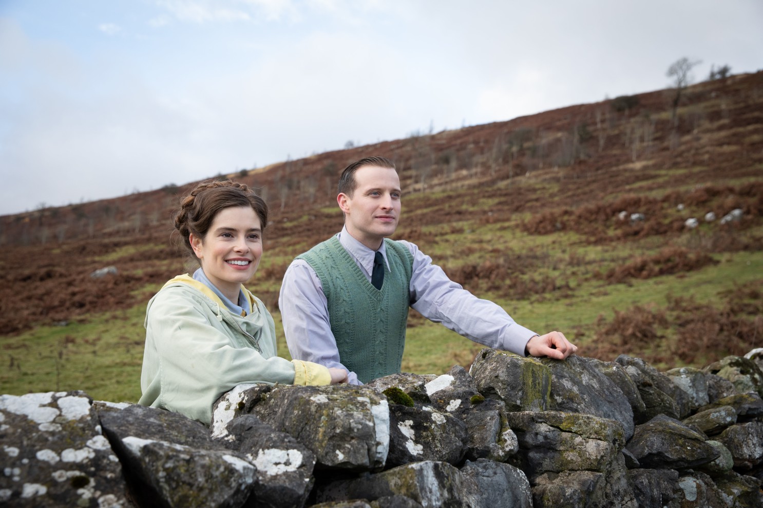 Helen, James's future wife, and James stand above a rocky wall in a shot from All Creatures Great and Small, 2020 (Photo by Playground Entertainment/PBS).