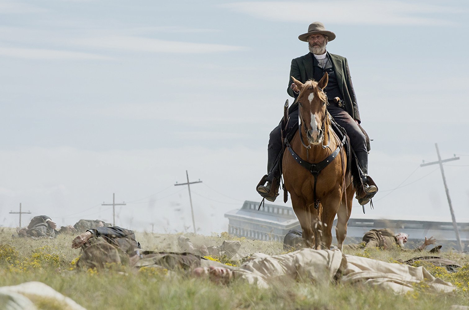 Godless. 2017. Netflix Entertainment.
Frank Griffin rides past a downed train and numerous wounded citizens.