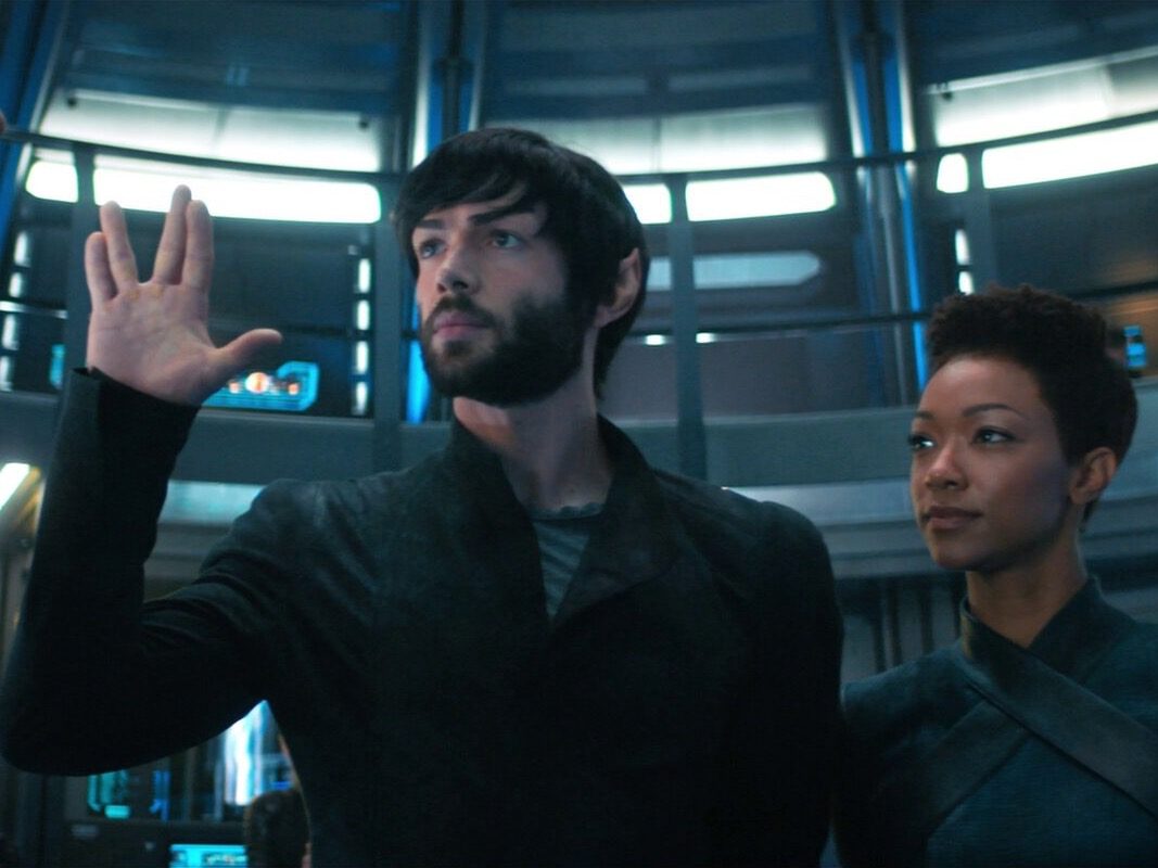 Spock and Michael stand on the ship's bridge together. Spock makes the "live long and prosper" hand gesture. 