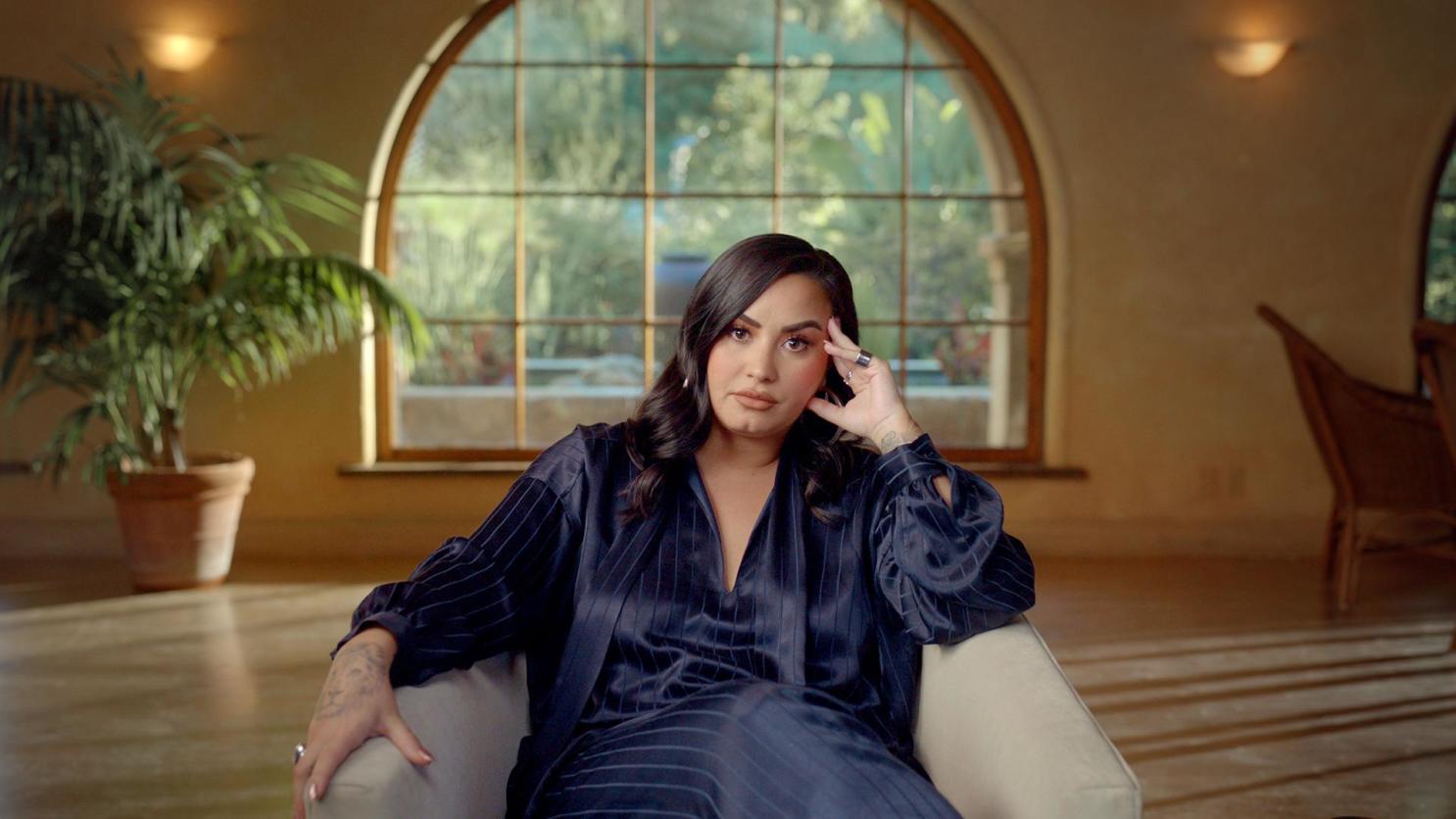 Demi Lovato sits in a chair as she is interviewed for her documentary "Dancing With the Devil." 