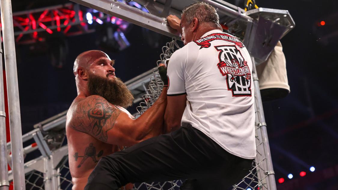 Braun Strauman furiously clinching Shane McMahon as he attempted to escape the steel cage at Night One of WrestleMania 37 (WrestleMania 37. 1972-Present. World Wrestling Entertainment.).