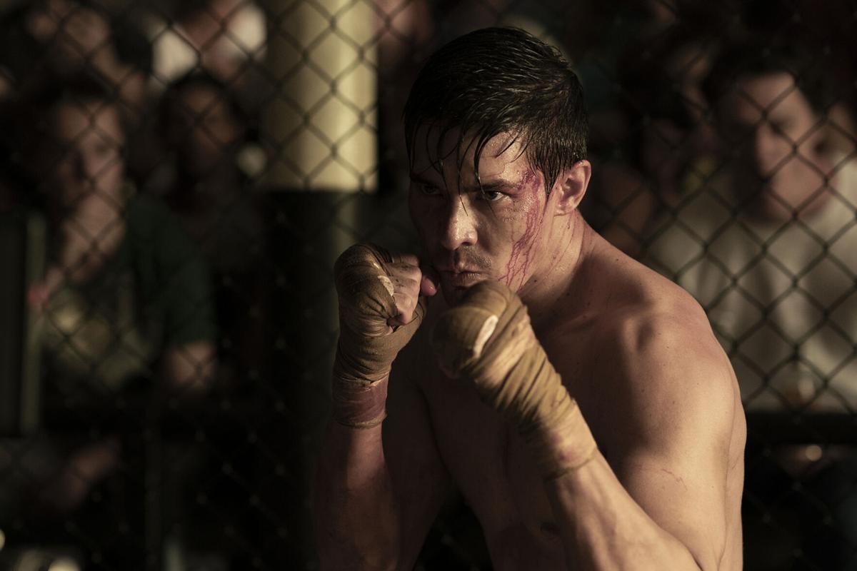 Lewis Tan as Cole Young in a cage fight in Mortal Kombat (2021). 