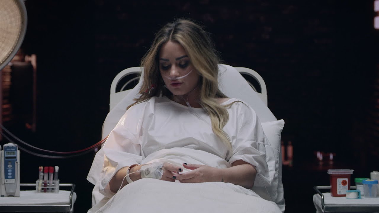 Demi Lovato lies in a hospital bed for her music video for single "Dancing With the Devil."