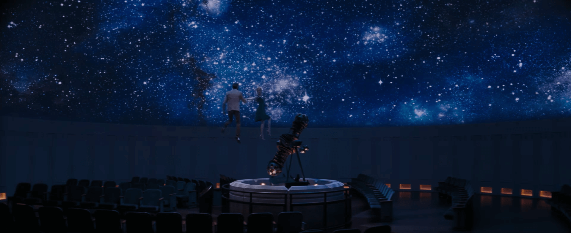 Seb and Mia are lifted into the planetarium's dome.