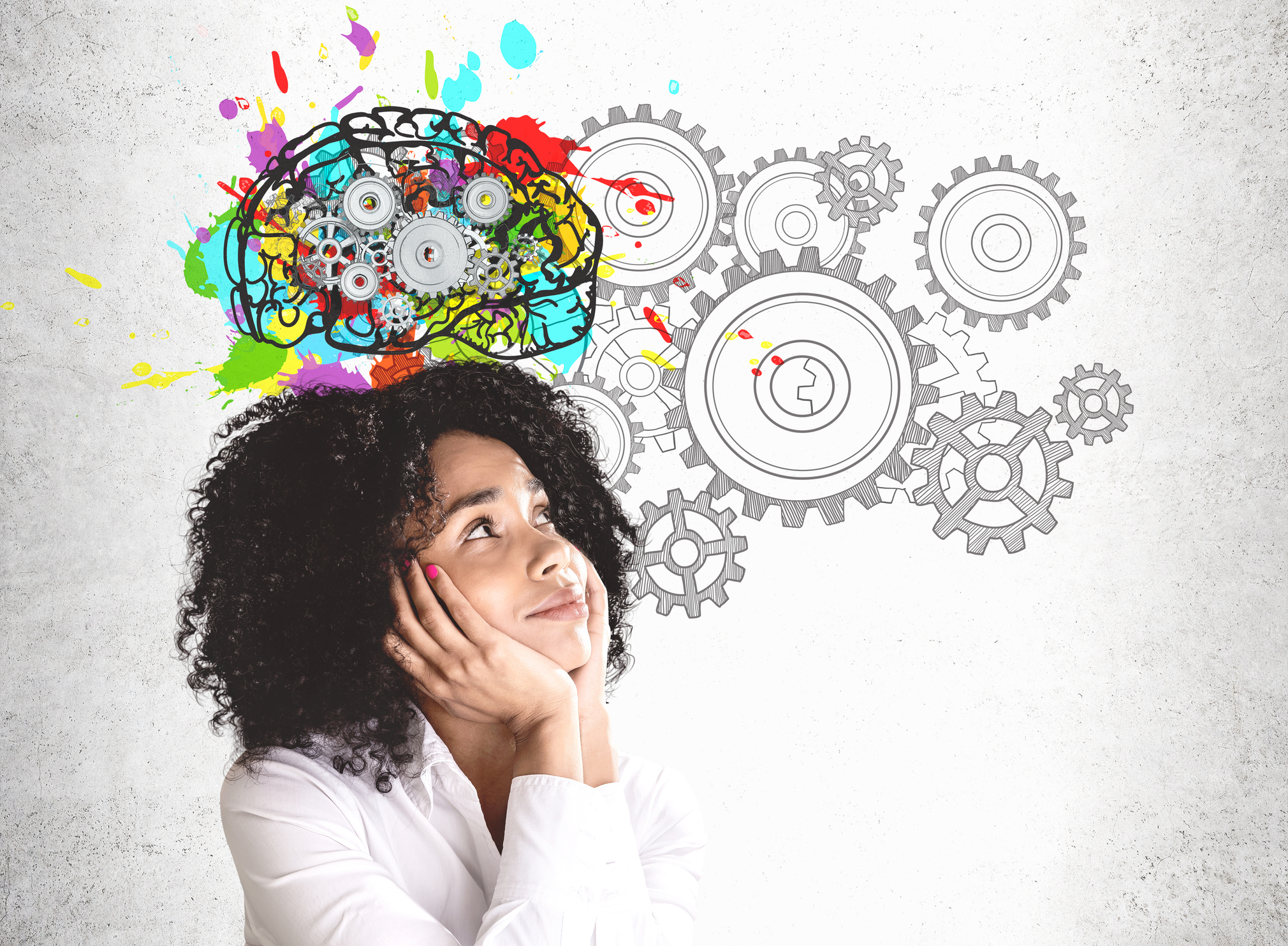 Smiling young woman in white shirt, looking at colorful brain sketch with gears.