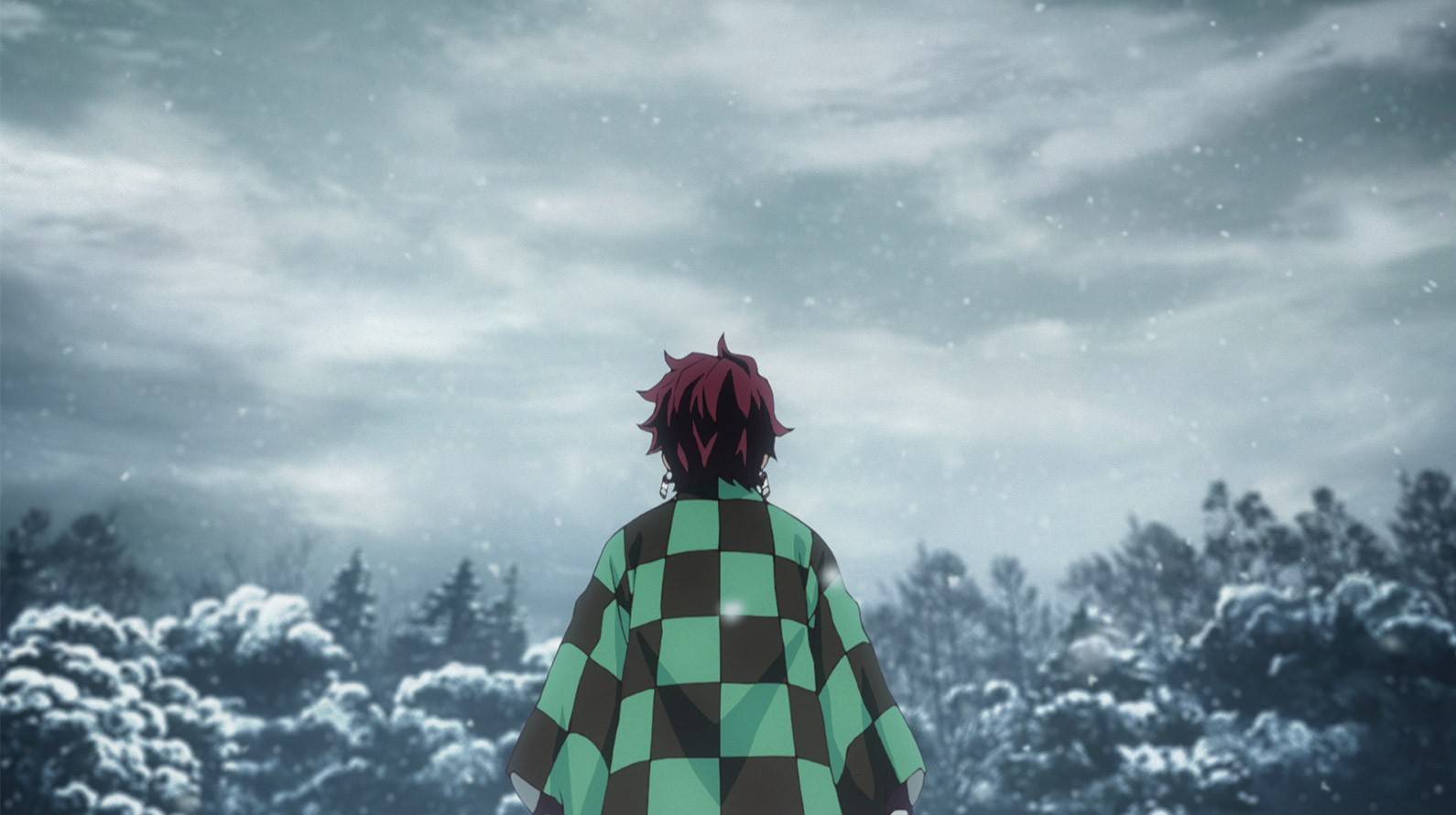 The main character of Demon Slayer, Tanjiro Kamado, stands on the snowy mountain of his old home. 