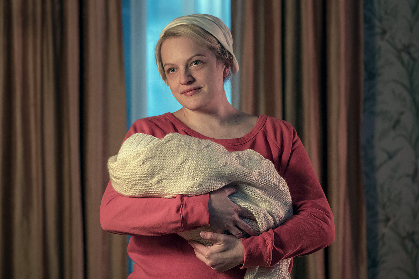 June holds her daughter Nichole, who is swaddled in blankets. 