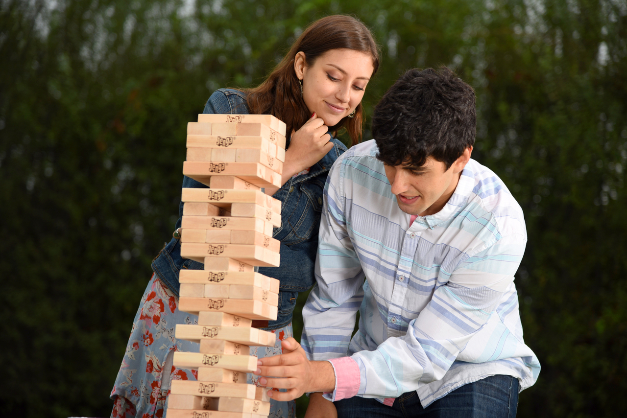 A family of two playing a friendly game of Jenga.