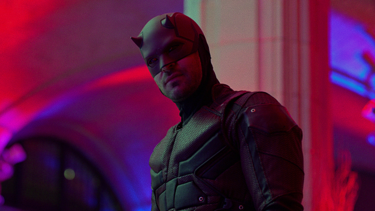 Daredevil stands in a pink colored room in  a still from the Netflix short series 'The Defenders'.