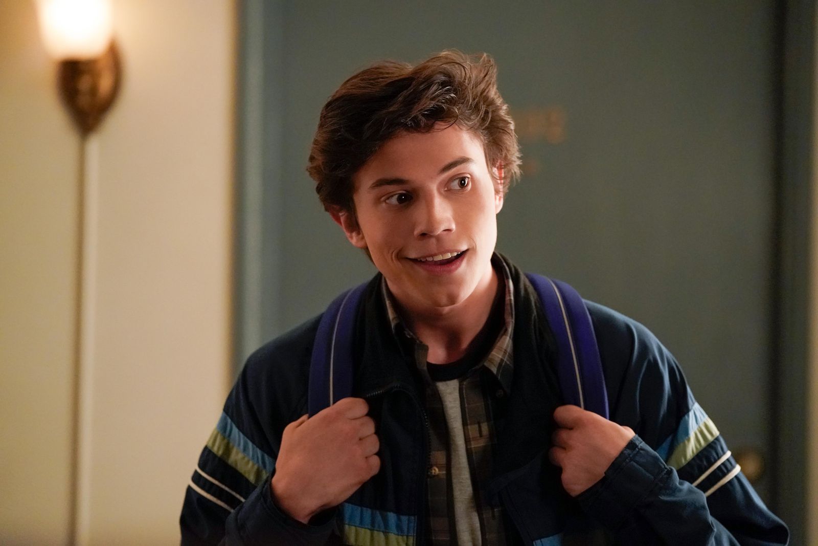 Felix Weston smiling as he waits for Victor in front of his apartment door in Love, Victor (2020-Present).