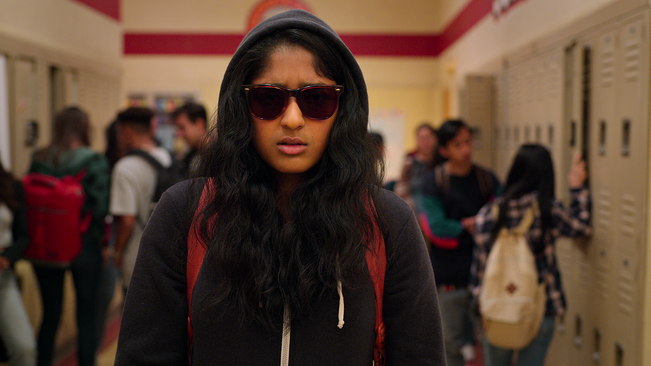 Never Have I Ever’s Devi as she has her hood and sunglasses on walking through her school’s hallway