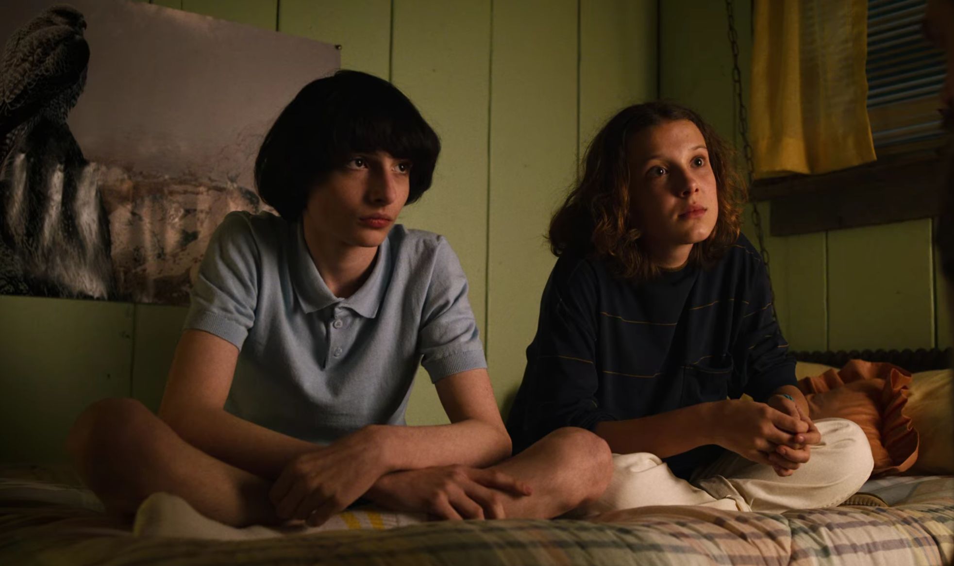 Mike and Eleven sit together in Eleven's room.