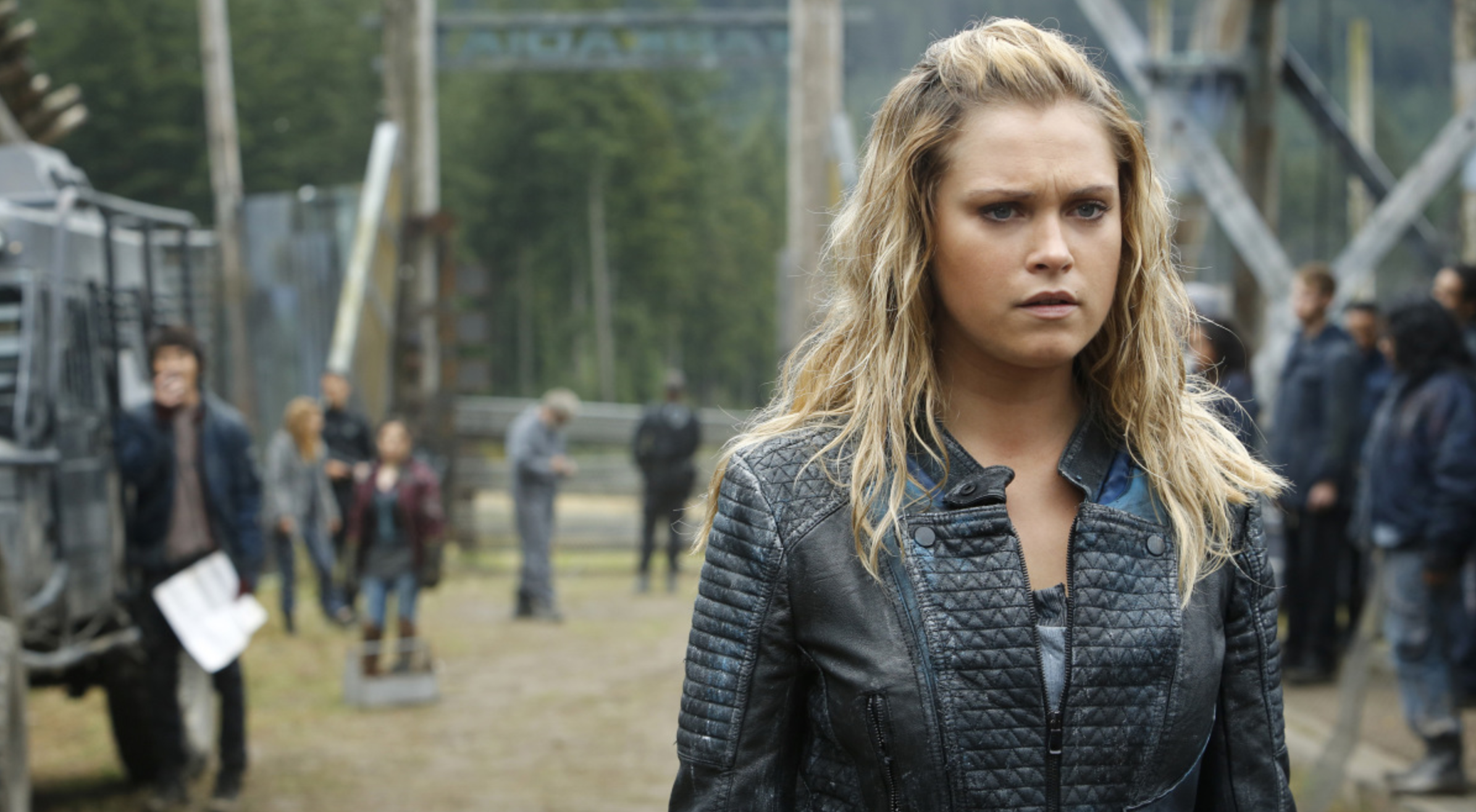 Clarke Griffin from "The 100" poses in front of their camp.
