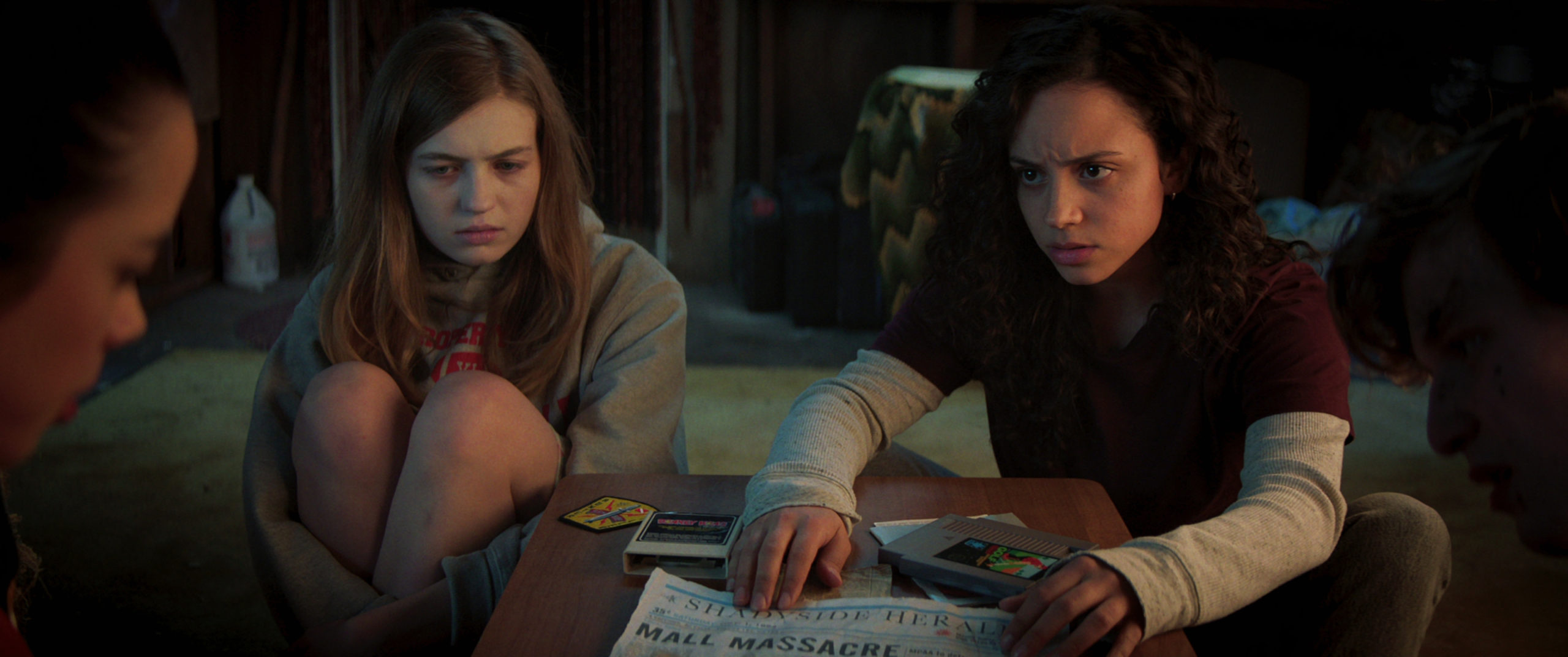 Sam (Olivia Scott Welch) and Deena (Kiana Madeira) are sitting.