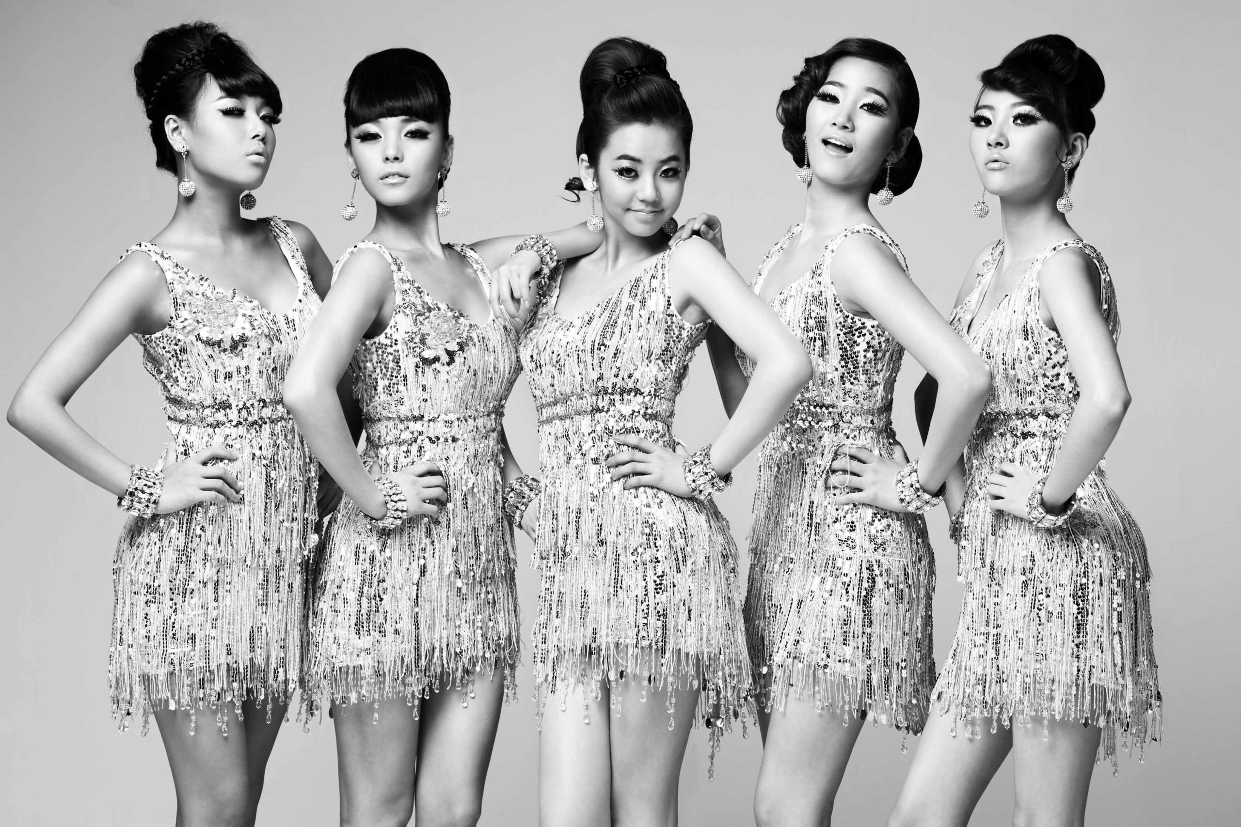 The five-member girl group Wonder Girls, in a black and white photo, dressed in 1960 styled dresses.