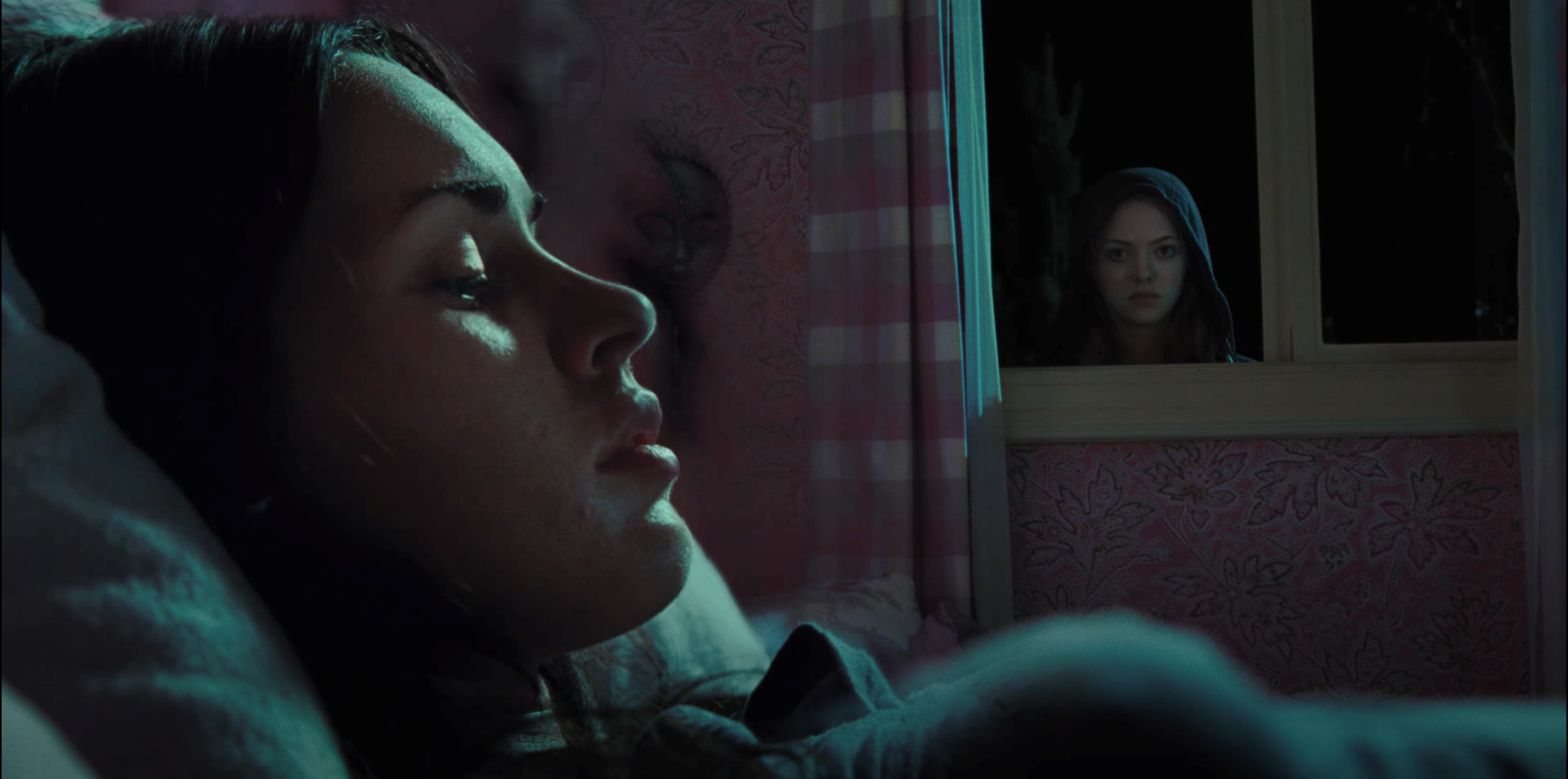 Needy's character gazes at Jennifer from the window as she lays in bed, in 'Jennifer's Body' (2009).