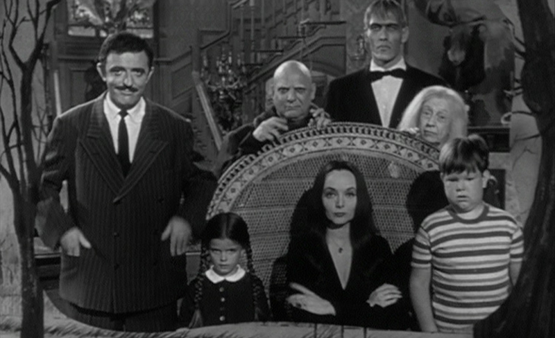 The original 1964, black and white Addams Family look into the camera for their theme song. 