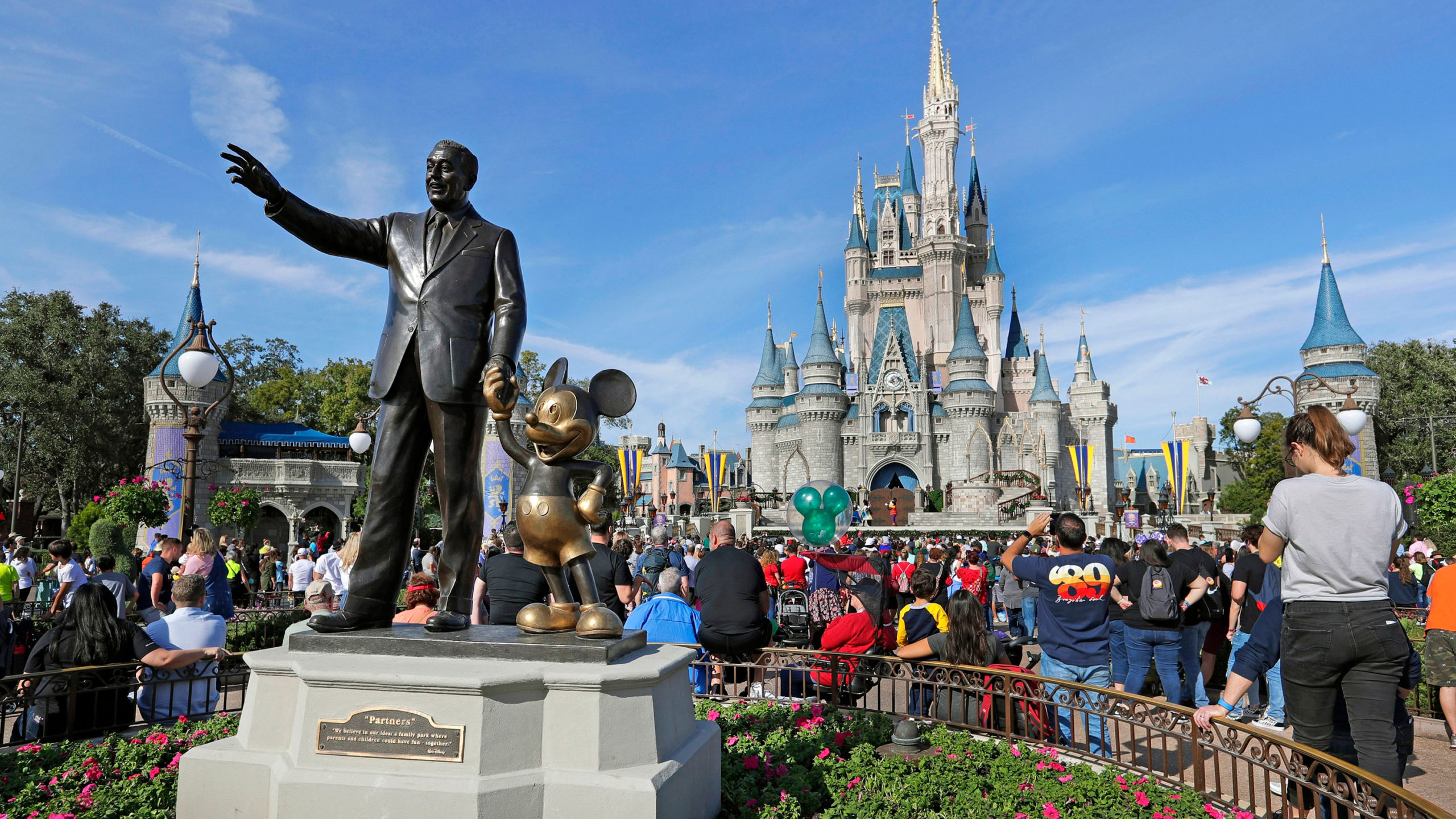 FILE - In this Jan. 9, 2019 file photo, guests watch a show near a statue of Walt Disney and Micky Mouse in front of the Cinderella Castle at the Magic Kingdom at Walt Disney World in Lake Buena Vista, part of the Orlando area in Fla. Magic Kingdom was the best-attended park in 2018 with 20.8 million visitors, followed by Disneyland in California with 18.6 million visitors. (AP Photo/John Raoux, File)