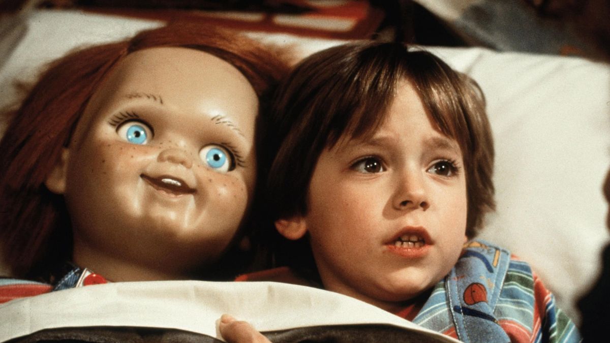 Chucky and Andy (Alex Vincent) laying in bed in Child's Play (1988).