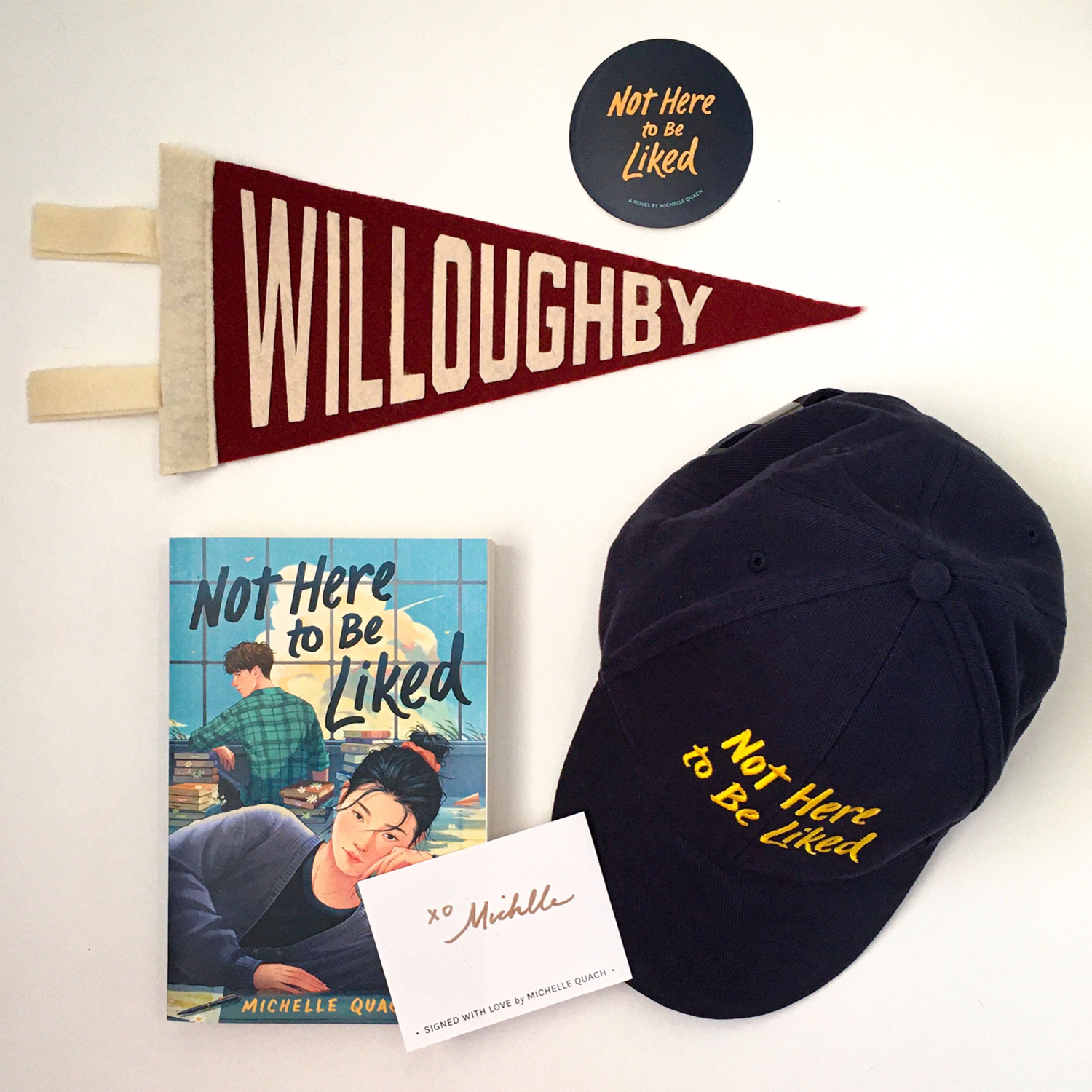 Merchandise of the book Not Here to Be Liked, featuring a hat with the book title, a flag with school's name Willoughby on it as well as  a sticker.