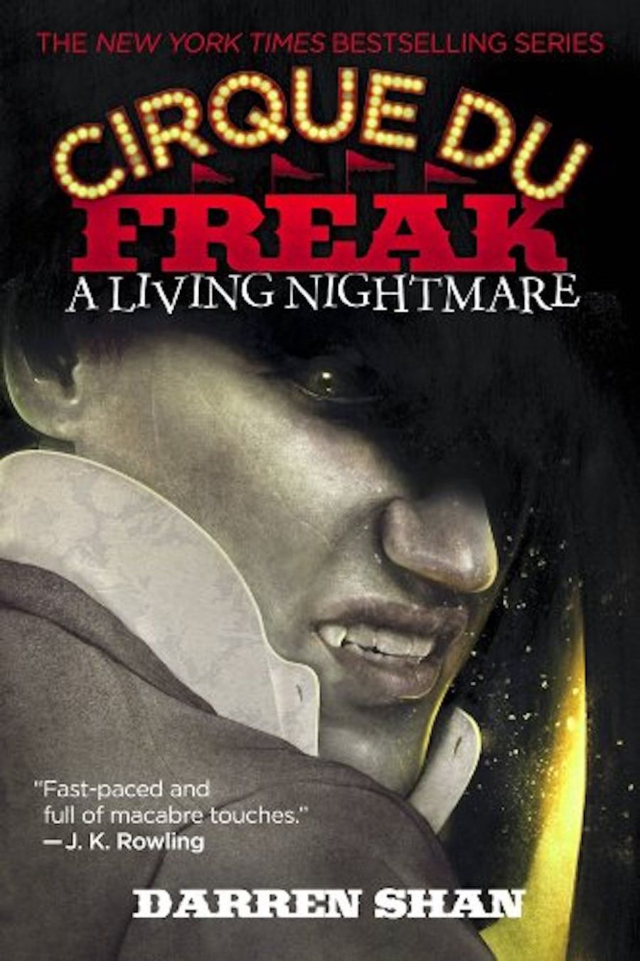 The front cover of the first book in the Cirque Du Freak series. A vampire looks out, showing its fangs. 