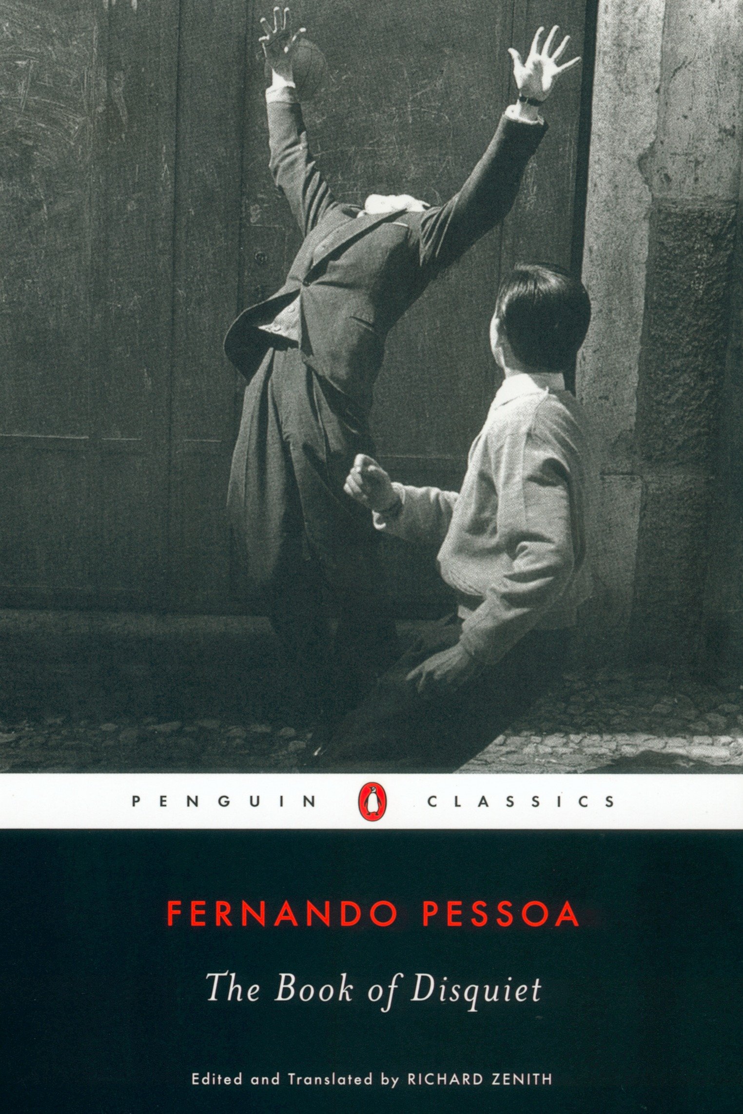 A cover of the Penguins Classics edition of The Book of Disquiet. It is a black and white photo of a man throwing his hands in the air, and the back of a boy's head, looking at the other man. The text "Fernando Pessoa" is in bright orange letters, characteristic of Penguin Classics. 