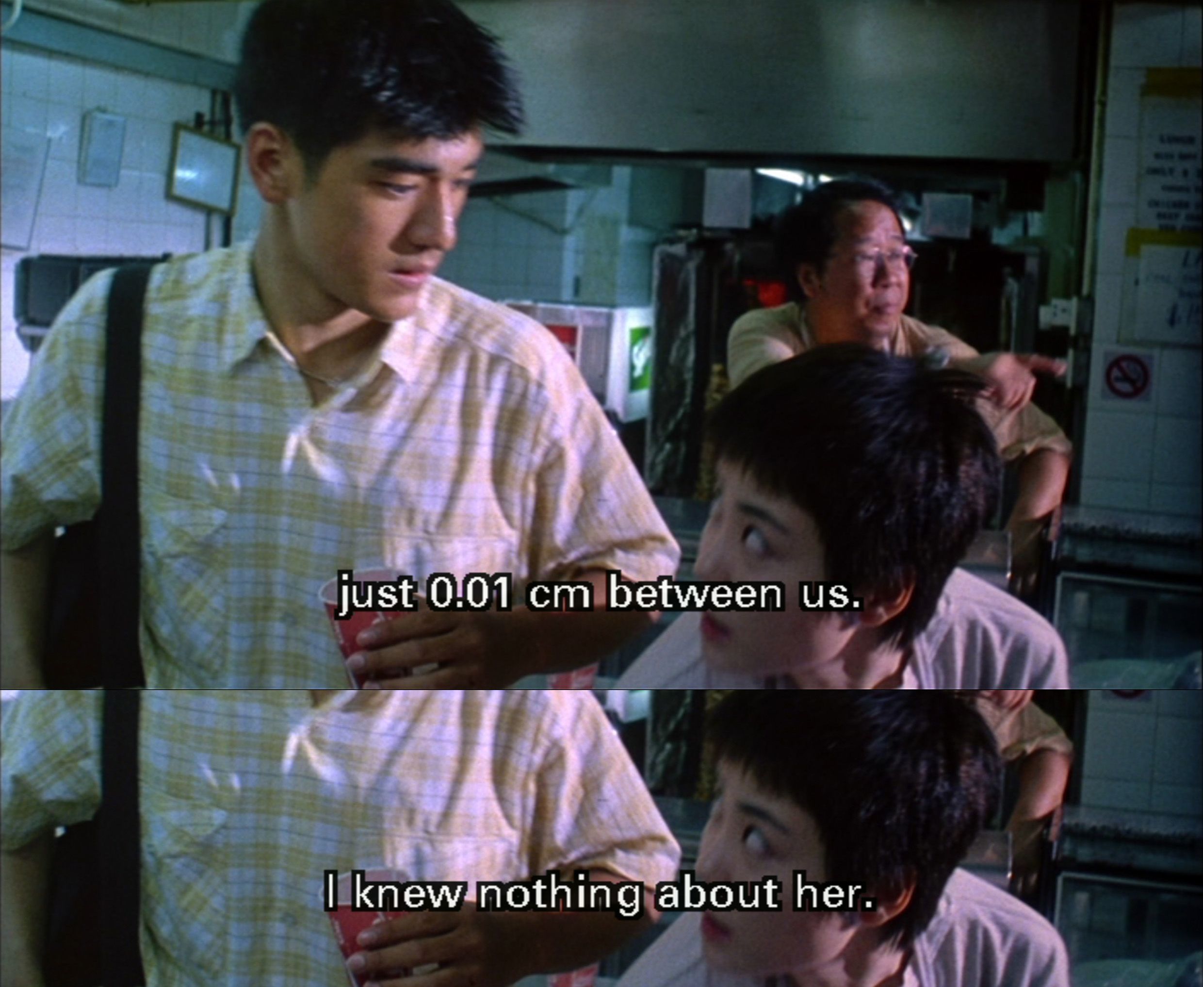 This is a film still from Chungking Express. Faye and He Qiwu meet, bumping into one another and sharing a glance. It reads "just 0.01 cm between us. I knew nothing about her."