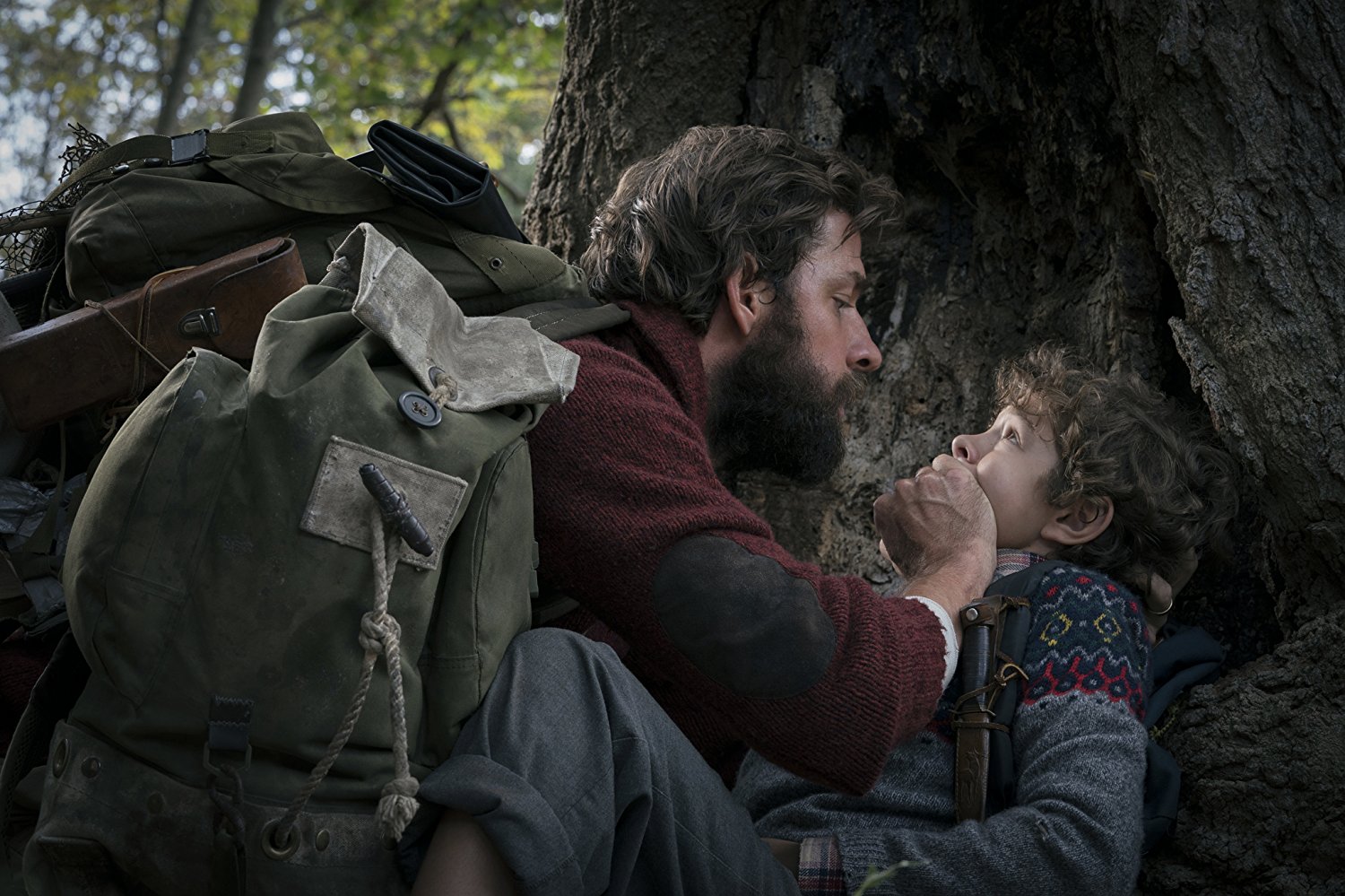 Lee Abbott (John Krasinski) covers his son (Noah Jupe)'s mouth to stop him from making noise outside.