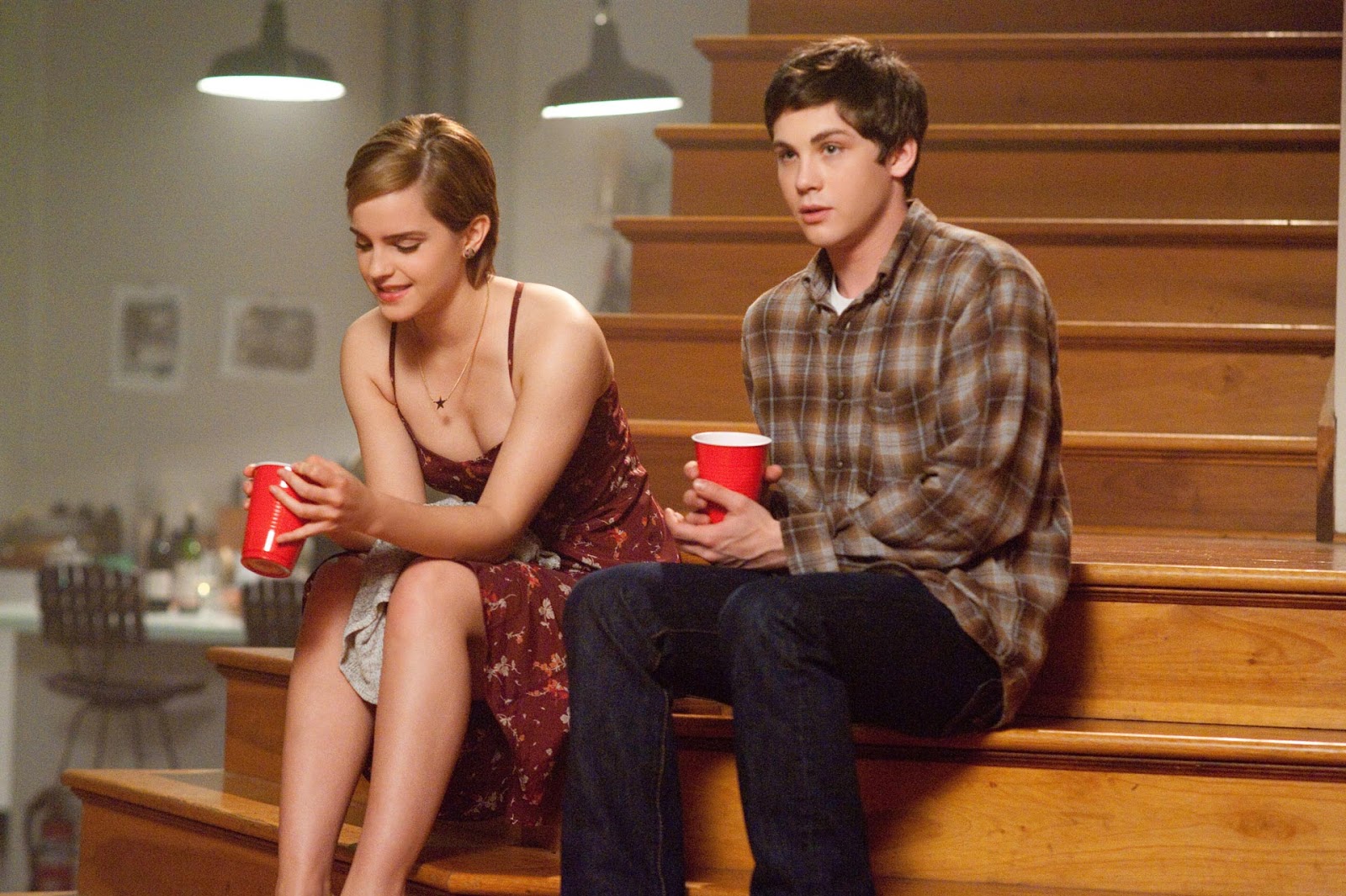 Charlie and Sam sit on the steps and talk at a party, in 'The Perks of Being a Wallflower' (2012). 