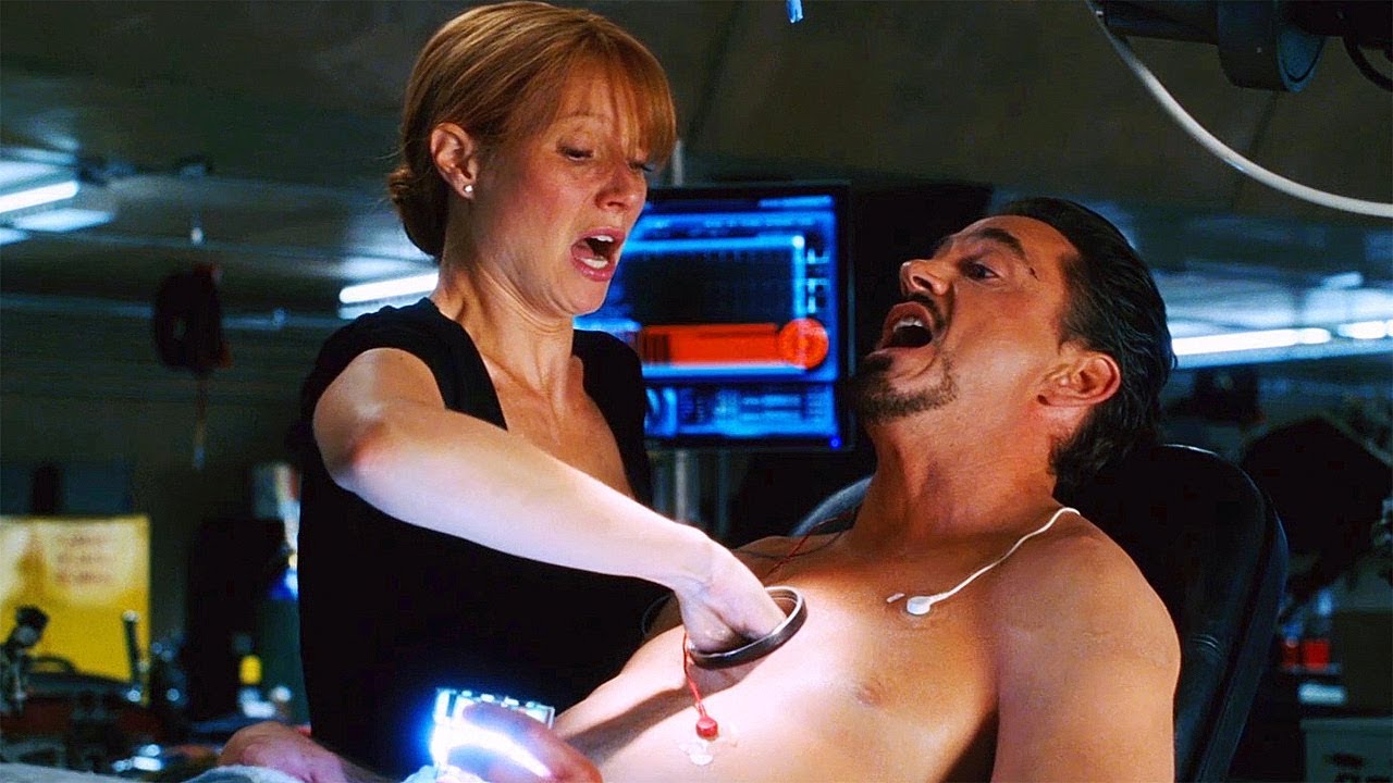 Pepper Potts helping Tony Stark switch out his arc reactor in Iron Man (2008).