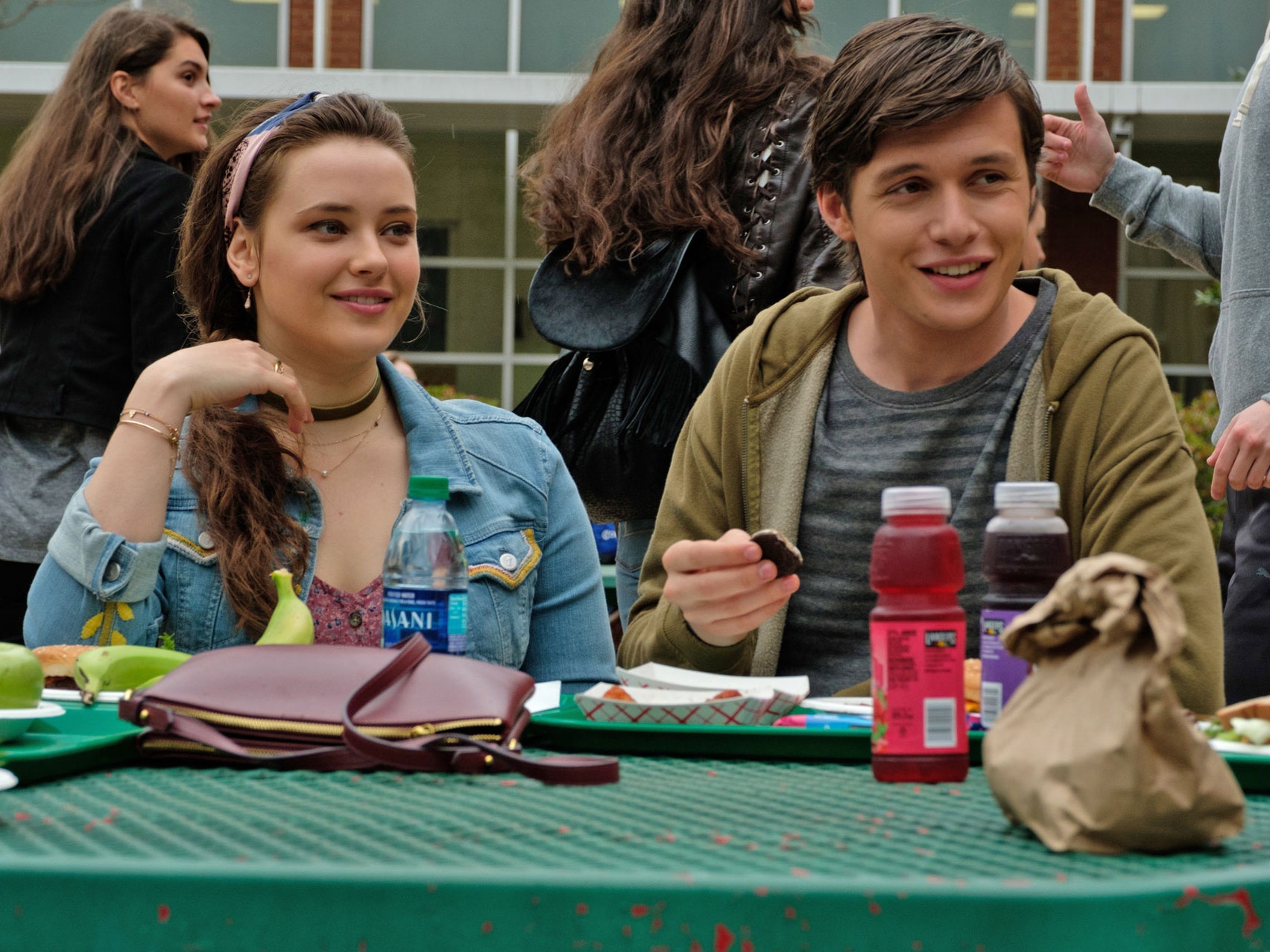 Leah (Katherine Langford) and Simon (Nick Robinson) eat lunch at a table outside. Berlanti, Greg Dir. Love, Simon. 2018