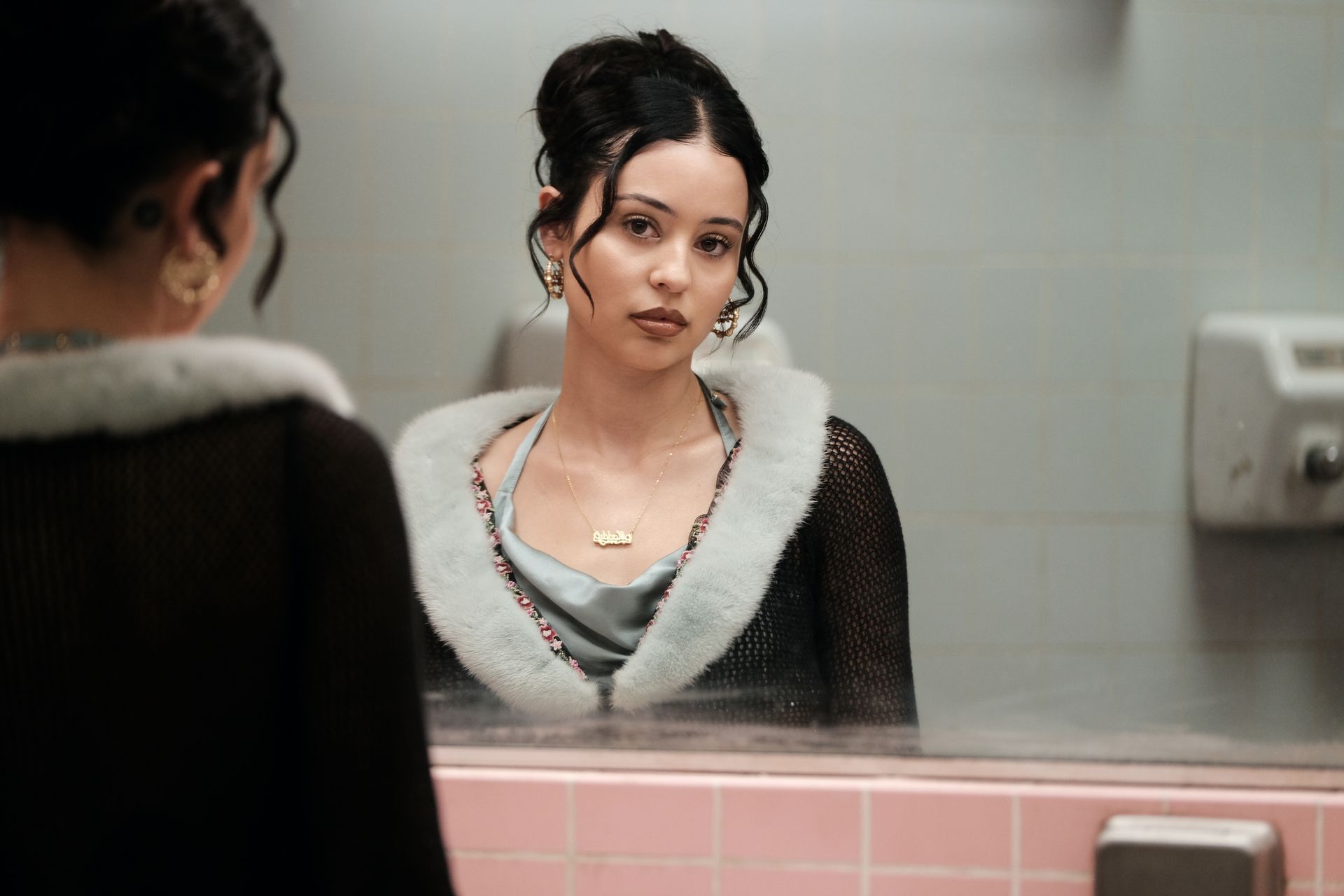 Maddy Perez looks at her reflection in the bathroom mirror in Euphoria. 