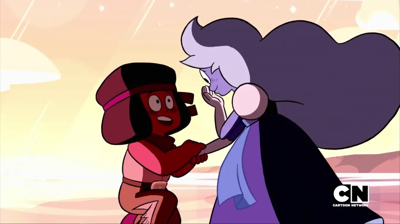 Two characters from "Steven Universe," Ruby and Sapphire, are shown. Ruby is on one knee proposing to Sapphire. 