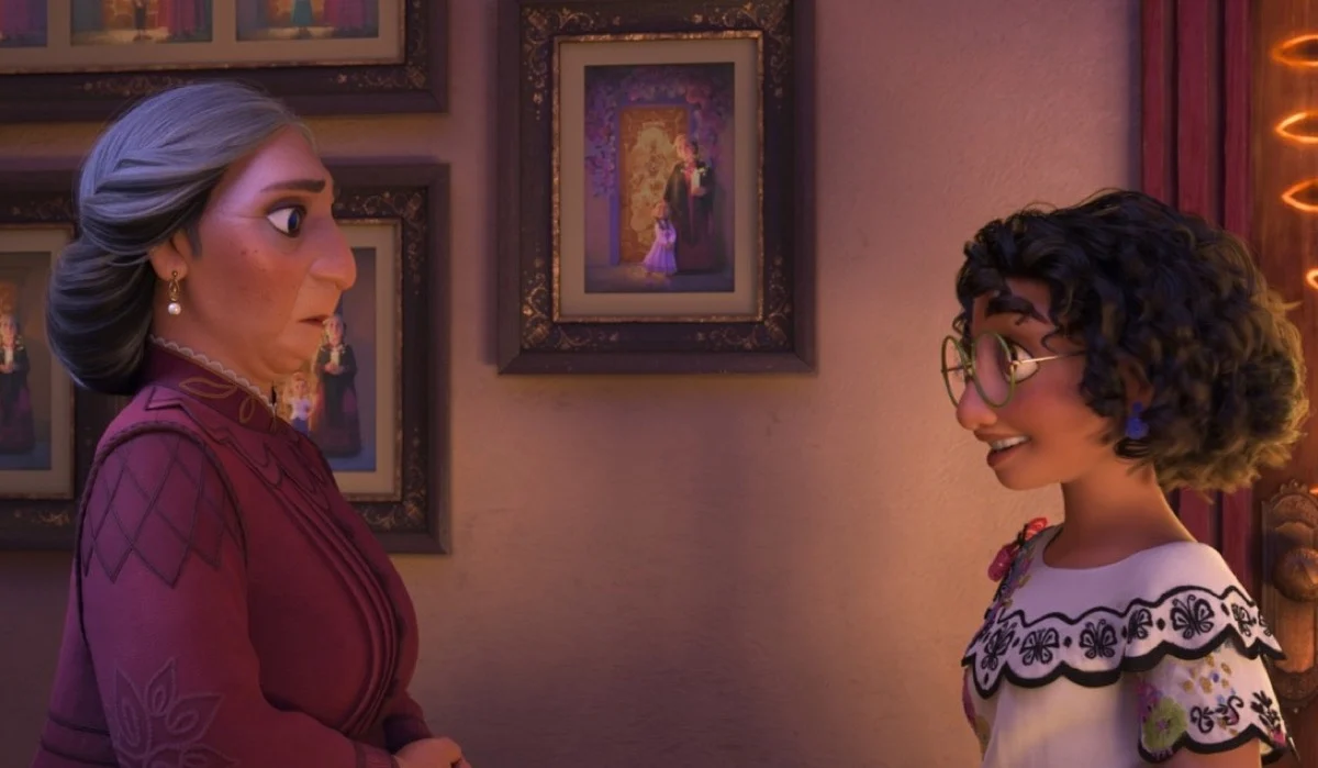 Mirabelle (Stephanie Beatriz) and Abuela Alma (María Cecilia Botero) converse in the hallway of Casa Madrigal.