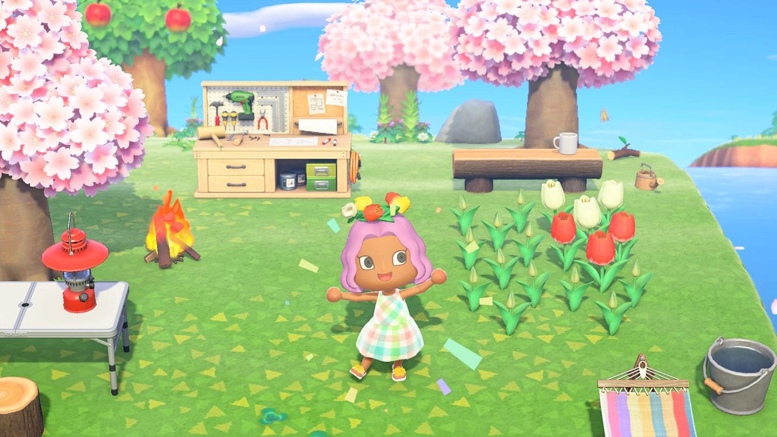 A Black, femme Animal Crossing character stands center-frame, emoting with arms outstretched. Their pink hair is topped with a flower crown and they are wearing a pastel plaid dress. Around them are various in-game items, flowers, and trees blooming with cherry blossoms.