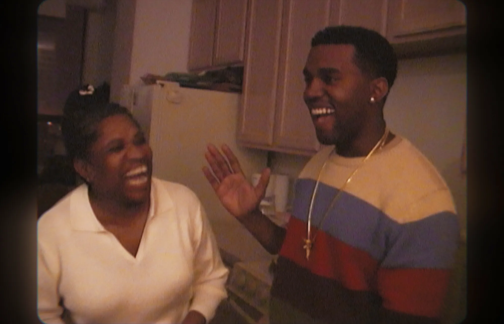 Kanye West and his mother Donda smiling and laughing together.