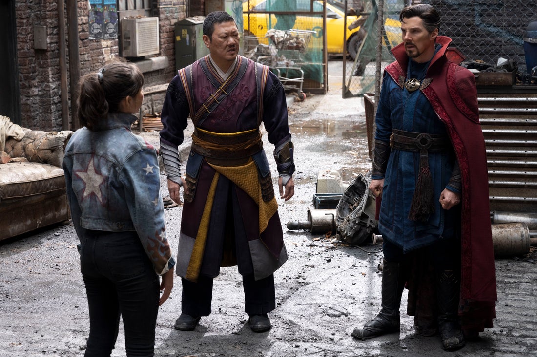 Xochitl Gomez as America Chavez being interrogated after the battle by Benedict Wong as Sorcerer Supreme Wong and Benedict Cumberbatch as Dr. Stephen Strange in Doctor Strange in the Multiverse of Madness (2022).