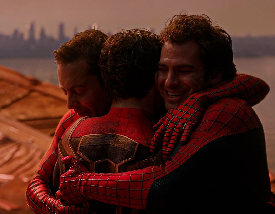 The three Peter Parkers, played by Tobey Maguire, Tom Holland, and Andrew Garfield, embracing after the final battle of Spider-Man: No Way Home (2021).