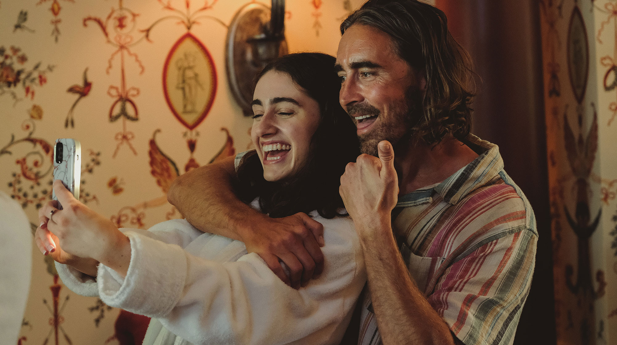 Rachel Sennott as Alice and Lee Pace as Greg taking a playful selfie together in Bodies Bodies Bodies (2022).