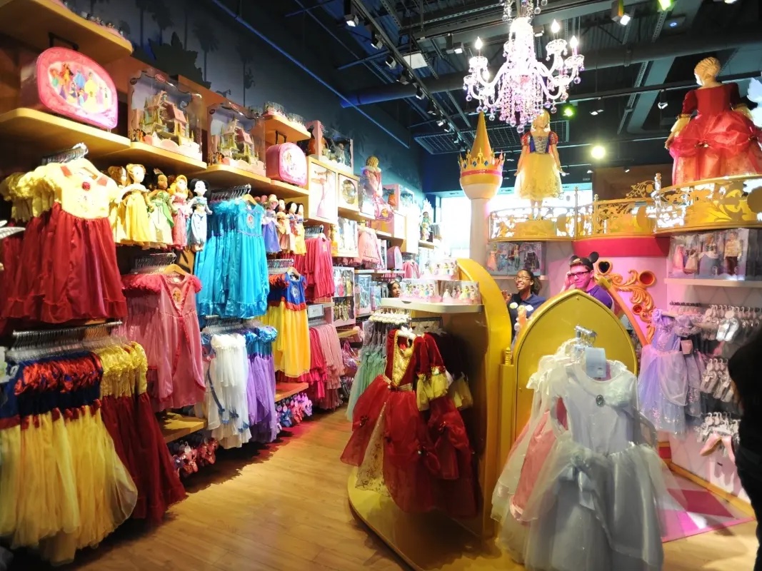 The inside of a Disney store showing princess dresses and children's outfits, which are known to be expensive. Larry Marano. Inside a Disney Store in Pembroke Pines, Florida. 2011.