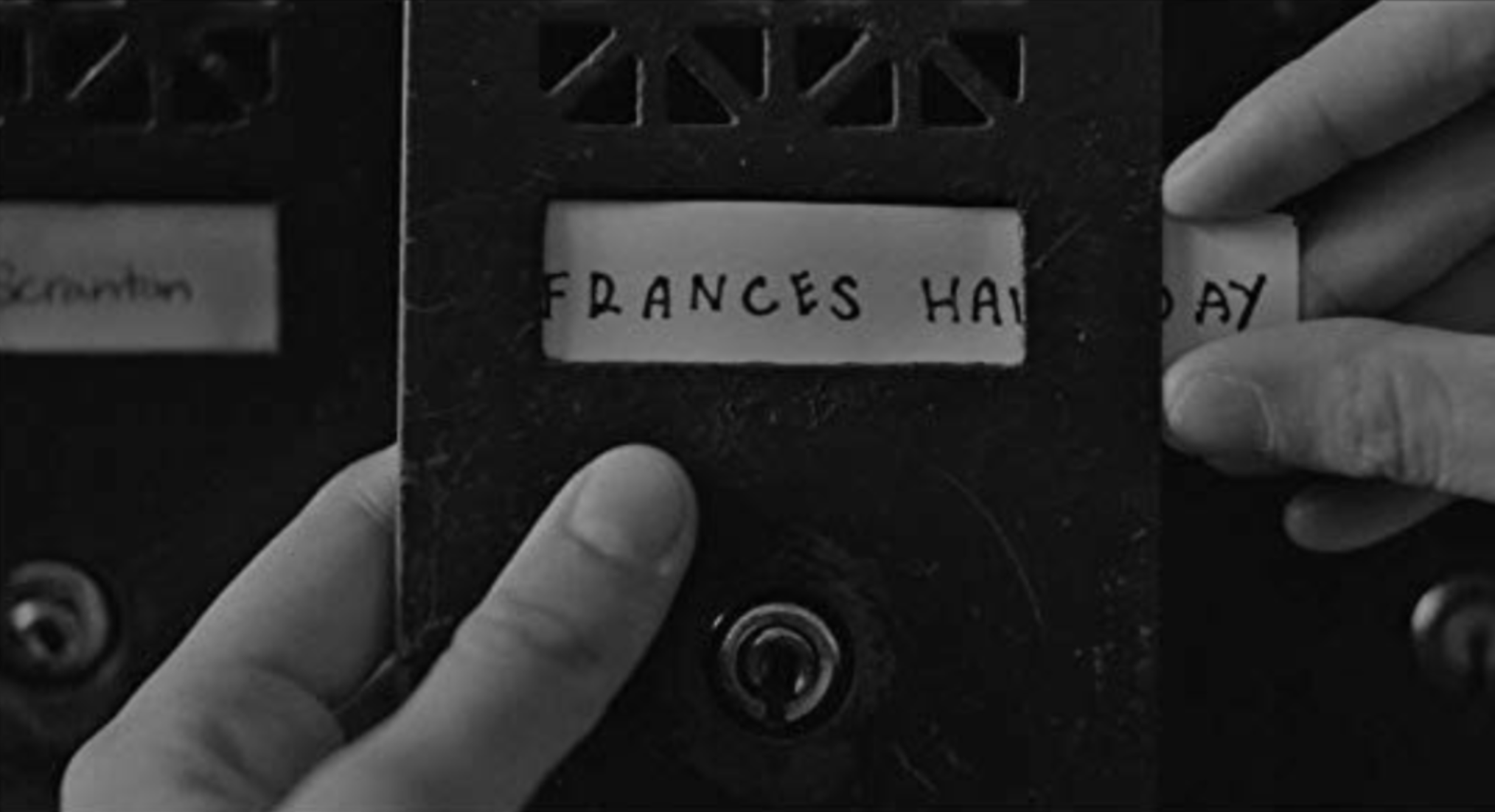 Frances putting her name on her mailbox in her new apartment. Baumbach, Noah, Dir. Frances Ha. 2012.