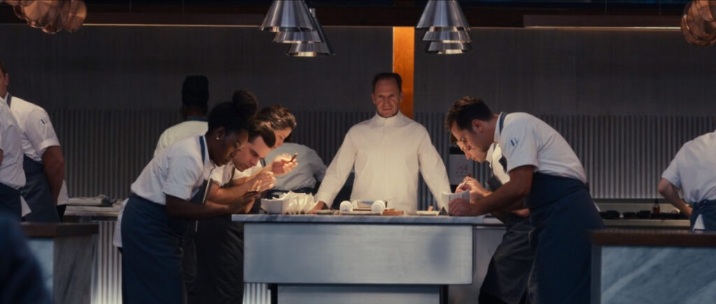 Chef Slowik watching his team plate a course in The Menu (2022).