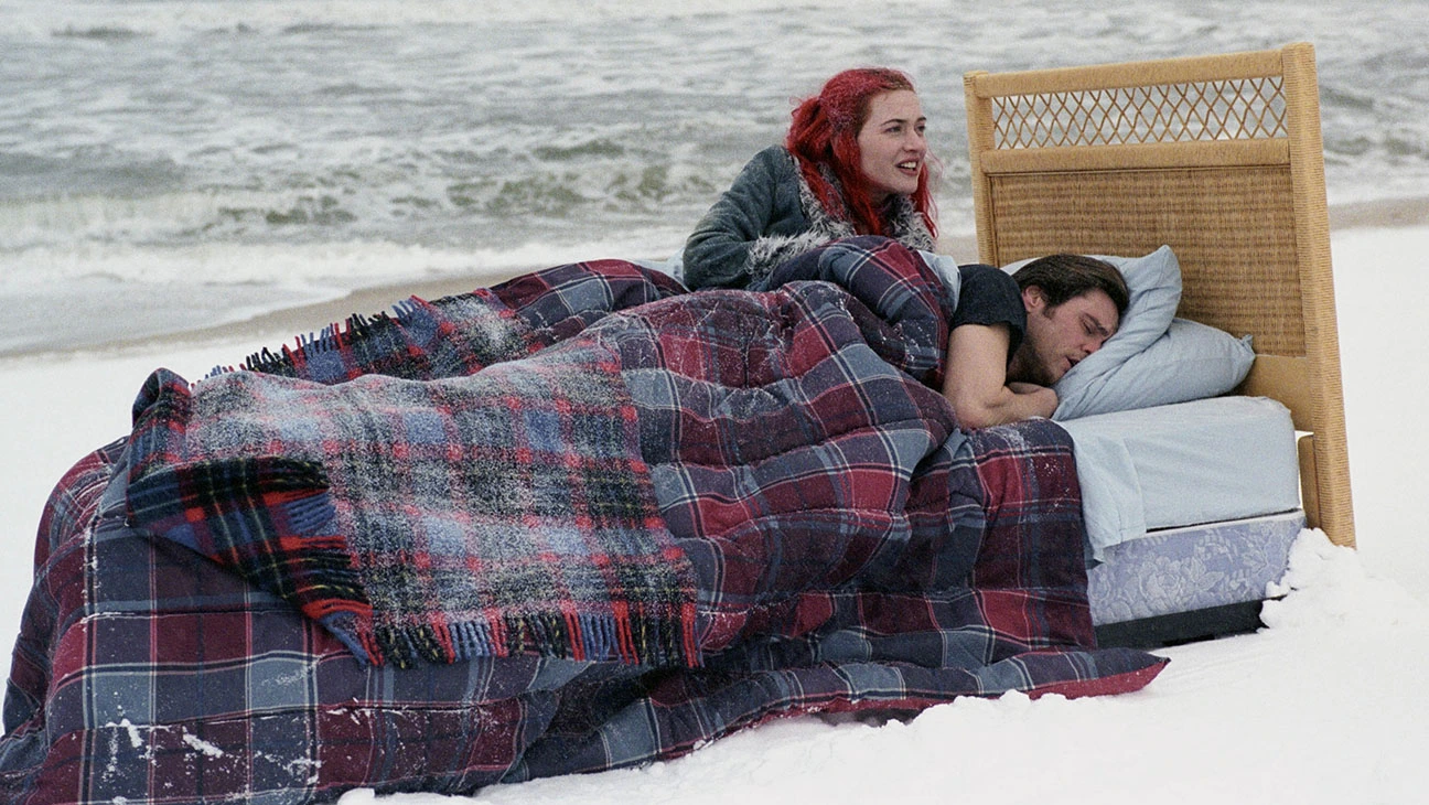 Shot from Eternal Sunshine of the Spotless Mind: Clementine and Joel laying in bed on a snow-covered beach