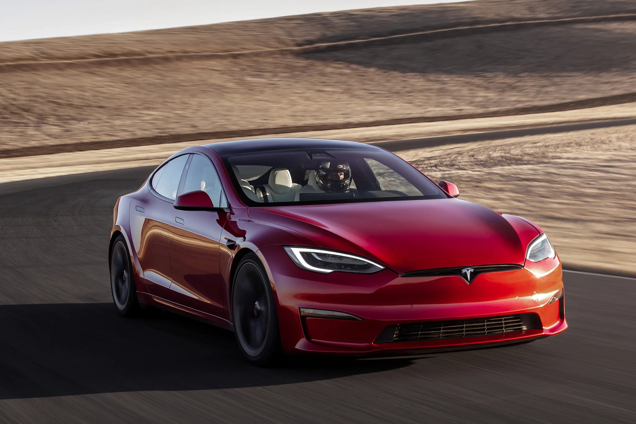 The red Tesla Model S Plaid, consisting of smooth lines and sporty appearance with a miniscule grill, is being driven on the track. (Holderith, Peter. “2022 Tesla Model S Plaid Review: A New 1,020-HP Chapter in American Luxury.” The Drive.)