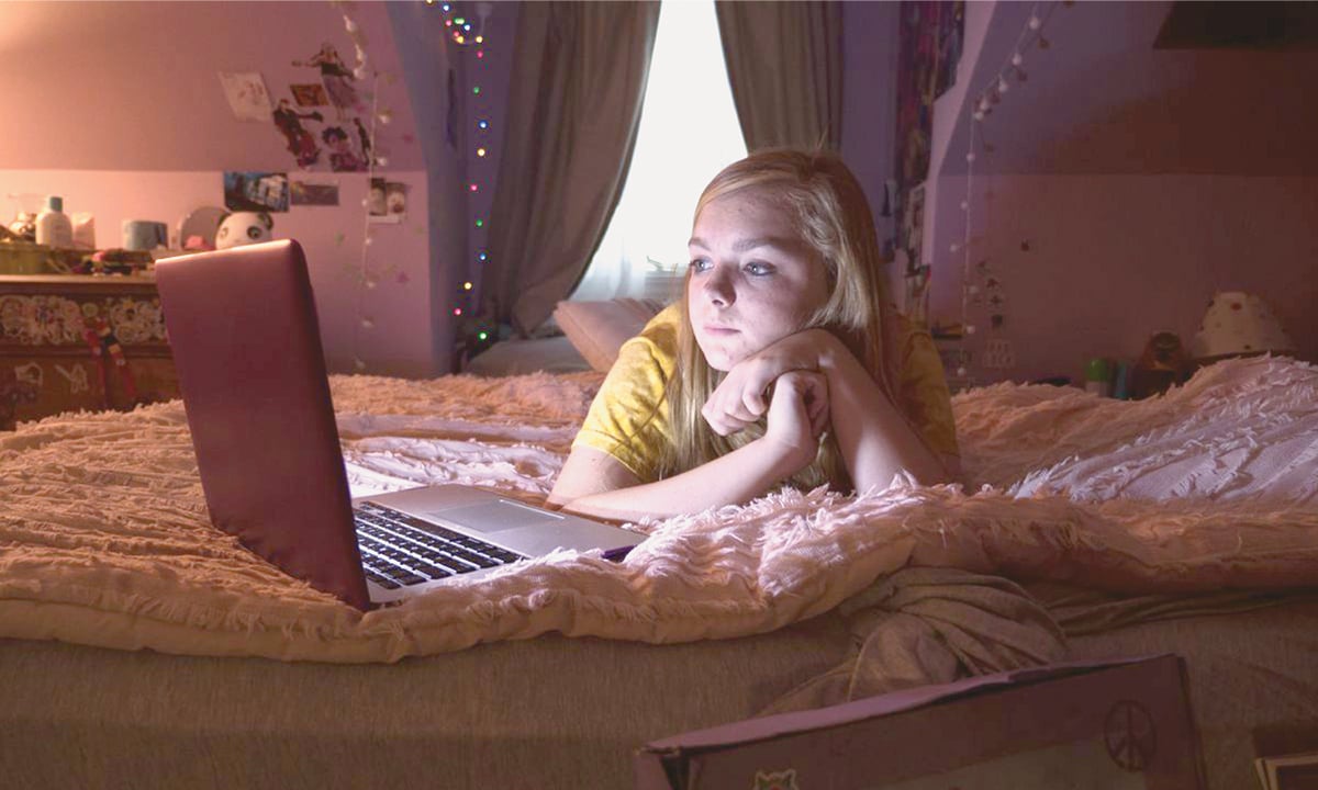 Elsie Fisher as Kayla, in Bo Burnham’s A24 film “8th Grade”, laying on her bed in her room in front of her computer.