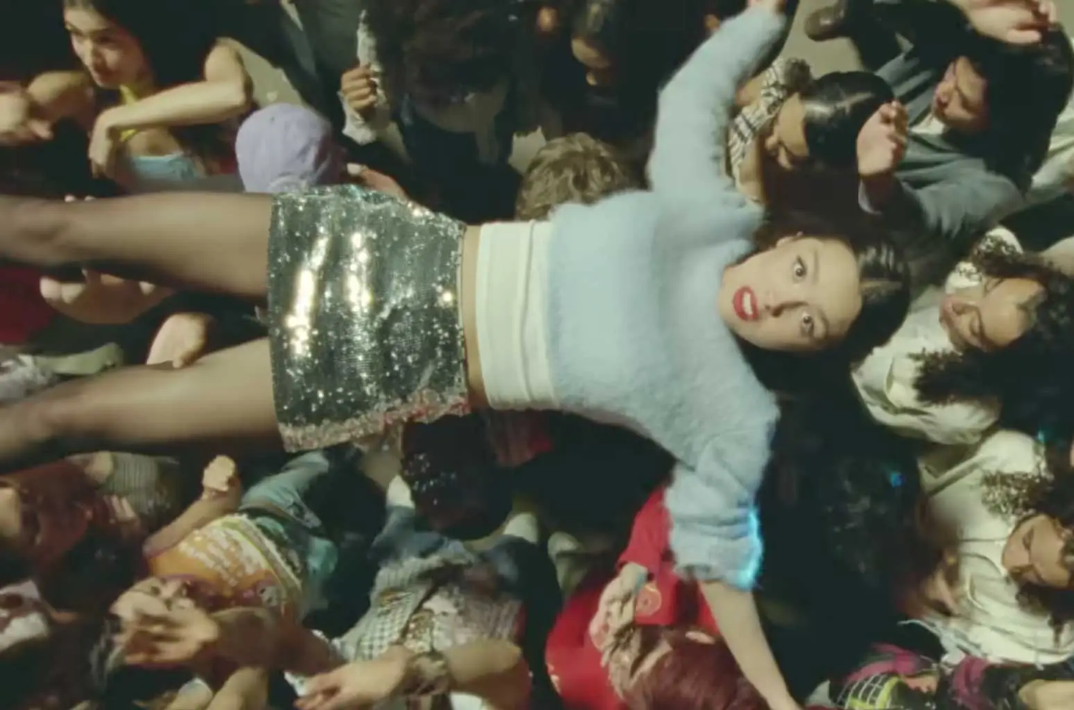 Shot from the "bad idea right?" music video: Olivia crowd surfing at a party. 
