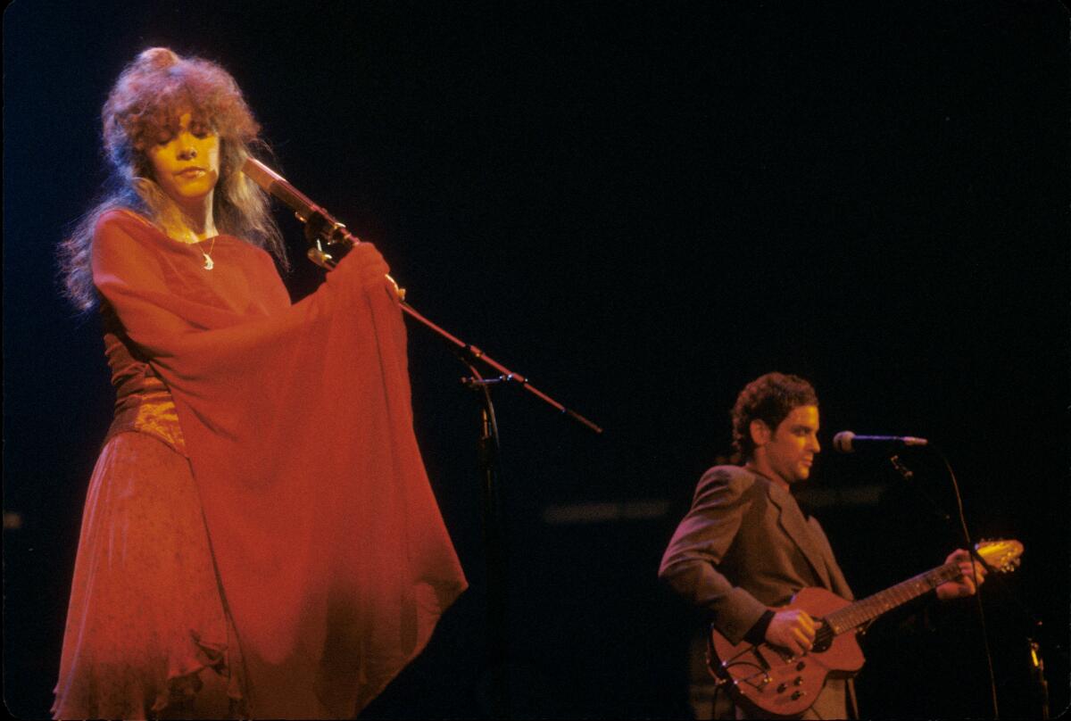 Stevie Nicks and Lindsey Buckingham perform on stage together. 