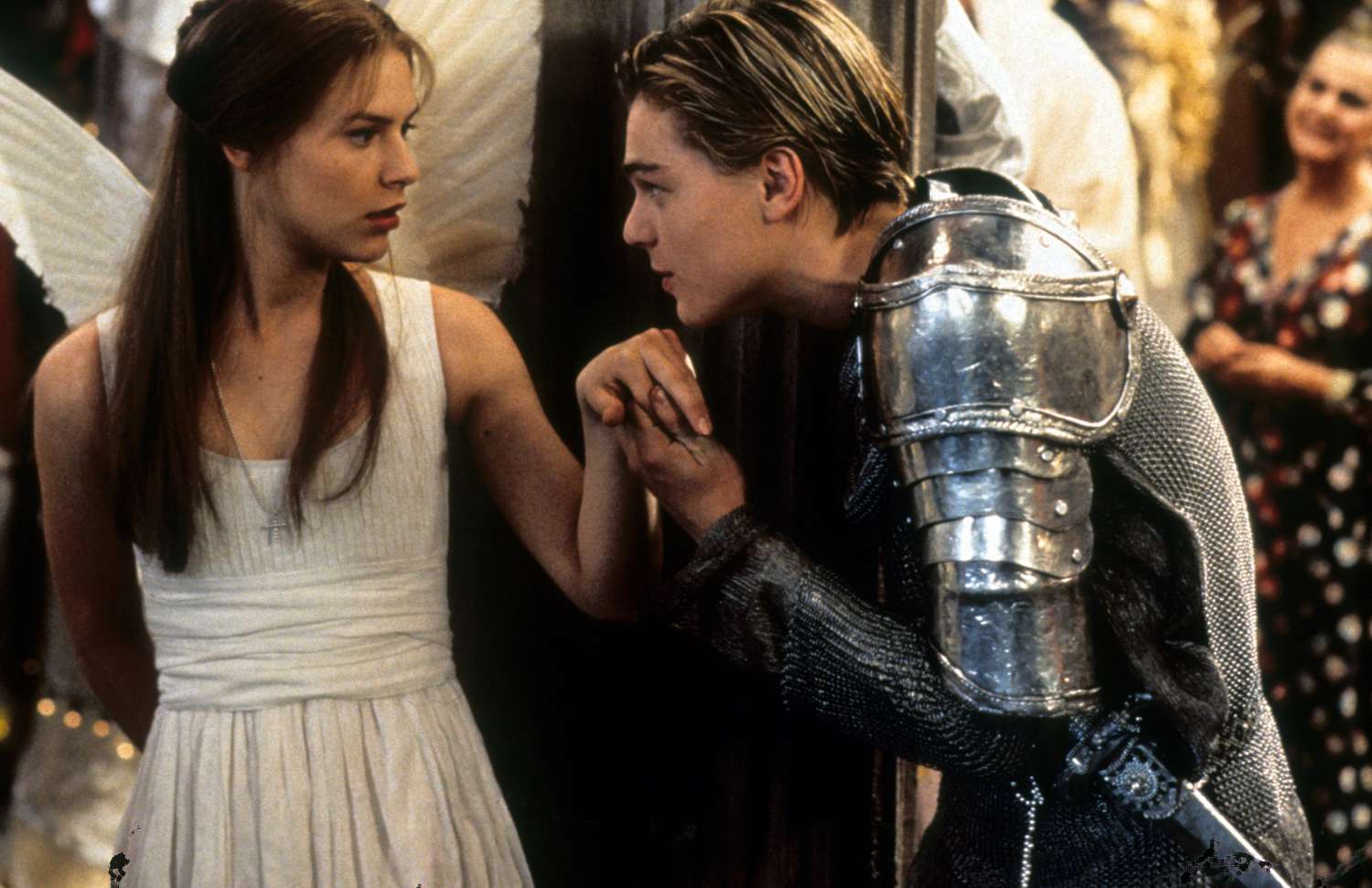 Shot from Romeo + Juliet (1996): Romeo kisses Juliet's hand at the Capulet ball. 