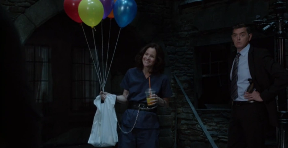 Yang holding balloons and wearing chains while helping Shawn solve a murder. 